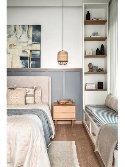 Simplicity and elegance define this master bedroom. I used MDF wainscoting on half of the bed wall, painted in a soothing grey, with the other half in pure white. This creates a calm backdrop for the light beige upholstered bed and oak side tables.
