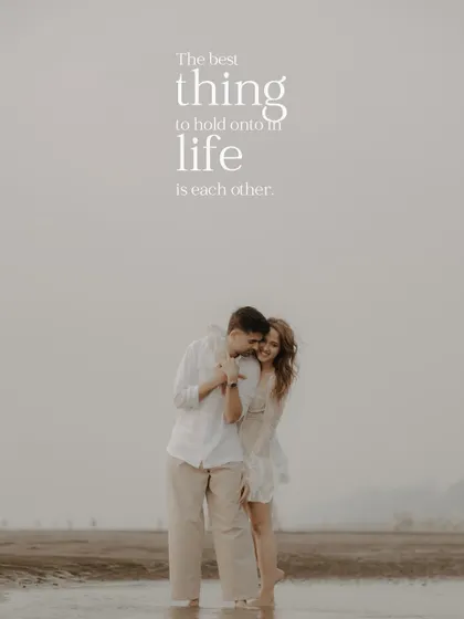 "The best thing to hold onto in life is each other." A wide shot of the couple embracing on a vast, empty beach, creating a sense of intimacy and solitude.