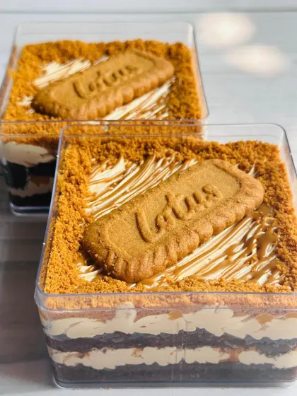 A side view of the Choco Biscoff Mousse Cake tub, revealing the delicious layers of chocolate cake and creamy Biscoff mousse.