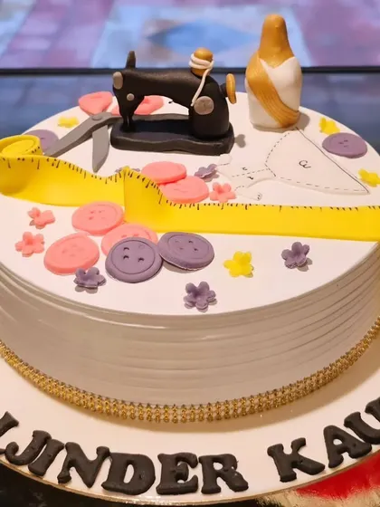 A cake that's tailored to perfection. This design celebrates a love for sewing with a miniature edible sewing machine, measuring tape, buttons, and a saree, all made from fondant.