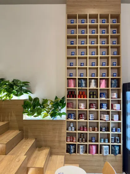 The merchandising unit at Beanly is a key brand identifier. This tall, grid-like shelf is visible from every corner of the cafe, showcasing the colorful product range and serving as a storage installation for personalized customer cups.
