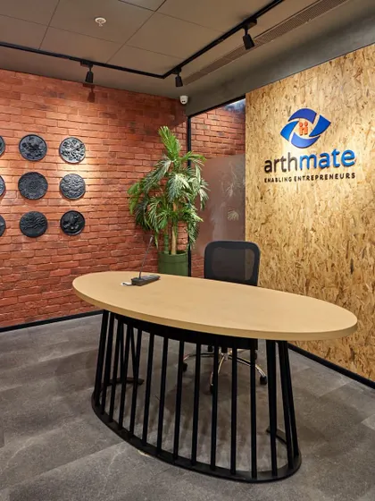 The reception for Arthmate in BKC, Mumbai, has a raw and rustic vibe. We used an exposed brick wall, an OSB panel with the company logo, and a sleek, modern desk to create a space that feels both grounded and entrepreneurial.