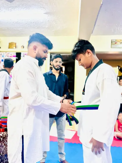 Tying a new belt for a student who has shown great progress and dedication.