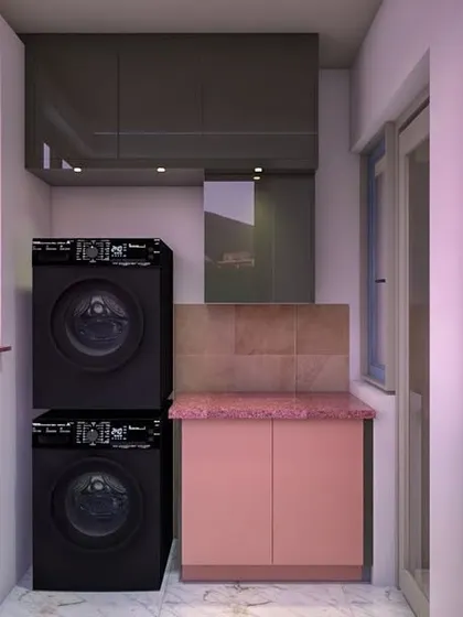 A functional utility area design with stacked washing and drying machines next to a small cabinet and sink, demonstrating our ability to maximize even the smallest spaces.