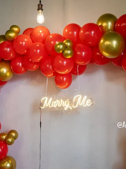 A detailed view of the 'Marry Me' neon sign, a key element in our proposal decoration packages. It adds a modern and romantic touch to any surprise setup.