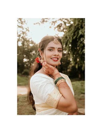 A happy and radiant close-up of a bride in her kasavu saree.