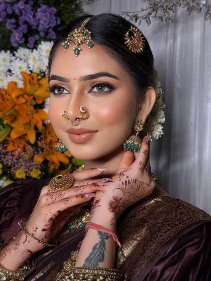 A detailed shot of the bride's makeup and jewellery, with the rich fabric of the saree providing a beautiful frame.