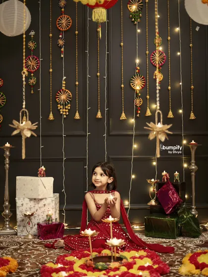 The wonder in her eyes says it all. Here, I wanted to capture a quiet moment of a little girl mesmerized by the diyas during our Diwali themed shoot, surrounded by a backdrop of lights and festive decor.