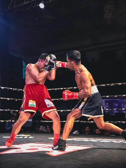 A wide shot of the action, showing two fighters exchanging blows under the bright lights of the arena.