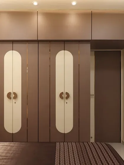 This image shows the full wardrobe with an integrated loft for extra storage. The design cleverly incorporates a hidden door to the attached bathroom, maintaining a clean and seamless look.