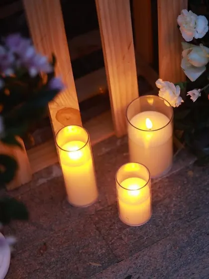 I use clusters of flameless candles in various sizes to create a safe yet magical ambiance. Here, they are placed alongside floral arrangements to light up the pathway for a romantic surprise.