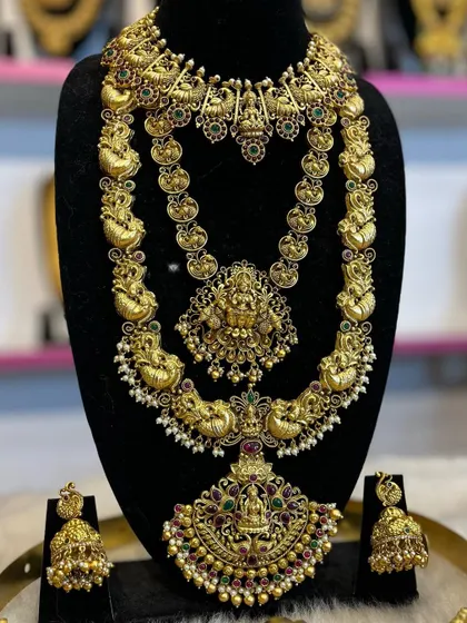 A three-layer temple jewellery set with intricate peacock and floral motifs. This is a complete rental solution for a grand bridal look.