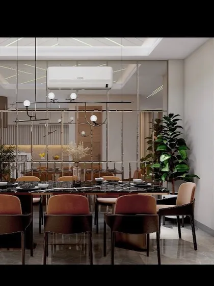 Another view of the Vasant Kunj dining space, highlighting the modern chandelier and the warm, inviting tones of the chairs against the sleek, reflective surfaces.