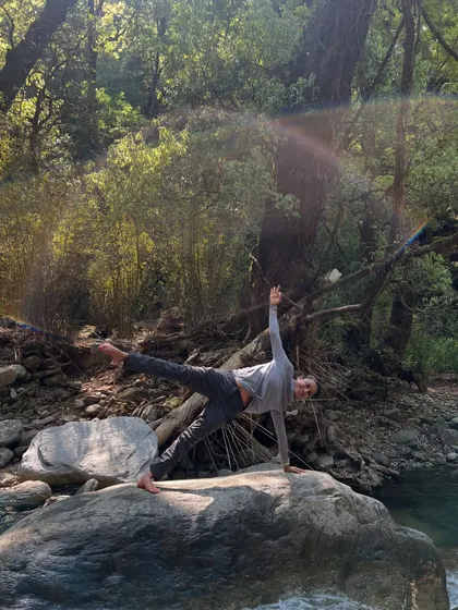 A moment of balance in Vasisthasana, or side plank, on a rock by a flowing river. The sound of the water and the stillness of the forest create a perfect harmony for a grounding and strengthening practice.