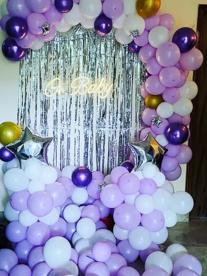 Another angle of the complete baby shower setup, showing the two balloon columns and the arch framing the central backdrop.