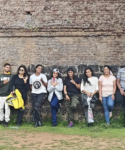 The group posing against an old fort wall during our Sakleshpura trip. Every ride is a chance to explore and discover something new.
