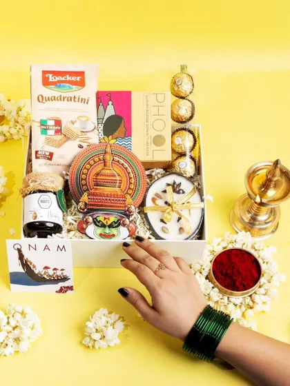 The 'Jamanthi Poo' hamper presented beautifully with jasmine flowers and a traditional lamp, capturing the complete essence of a festive Onam gift.