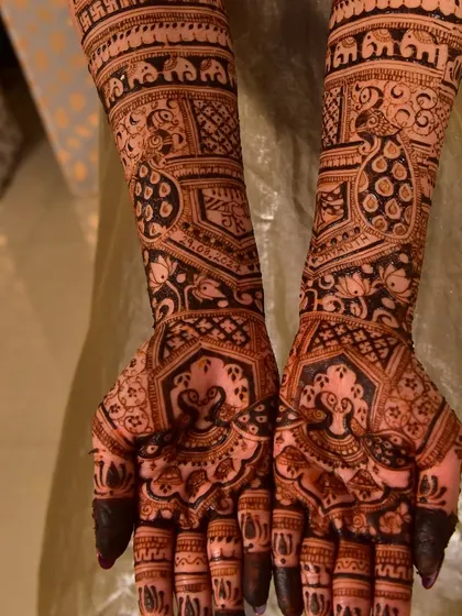 This intricate design is filled with auspicious symbols, including elephants, swastikas, and lotus flowers, all customized for the bride.