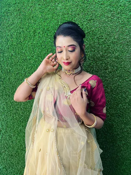 A beautiful pose showing the complete festive look. The client's soft glam makeup, elegant updo, and traditional attire are perfect for attending a wedding or any cultural celebration.