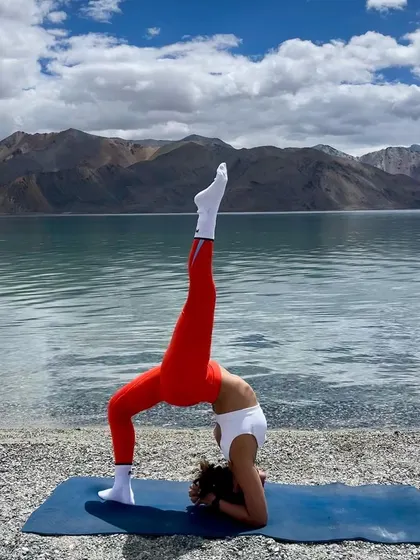 A forearm wheel pose with one leg extended, performed by the stunning Pangong Lake. This deep backbend variation requires significant shoulder opening and thoracic spine mobility.