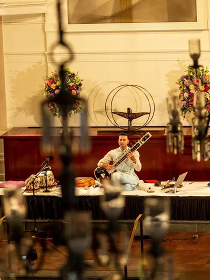 A creative angle of my performance, viewed through the venue's chandeliers, highlighting the unique and aesthetic experience I provide.