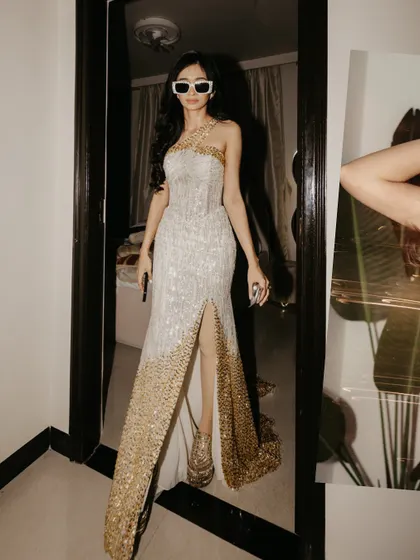 The bride showcases her stunning, high-slit reception gown with a cool and confident pose.