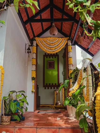 The entrance to the house, adorned with traditional marigold garlands, welcomes guests to the wedding festivities, starting with the Chapra Puje.