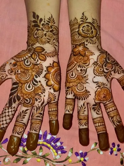 A lovely floral Arabic design with detailed finger work. The combination of bold flowers and delicate patterns on the fingers creates a balanced and beautiful look.