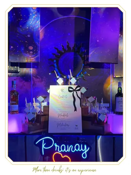 A personalized bar setup for "Pranay", featuring a custom neon sign and a celestial, galaxy-themed backdrop. This shows how we tailor every detail to the client's story.