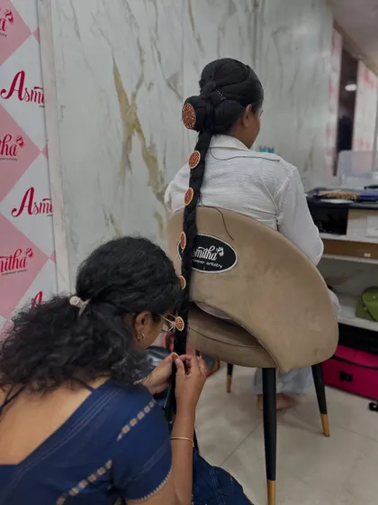 A student adding the finishing touches to a traditional bridal braid during an indoor portfolio session.