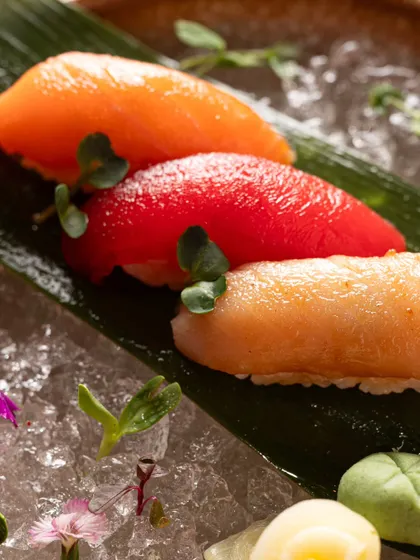 A macro close-up of three different types of nigiri. This detailed shot emphasizes the texture and freshness of the fish, key selling points for sushi.