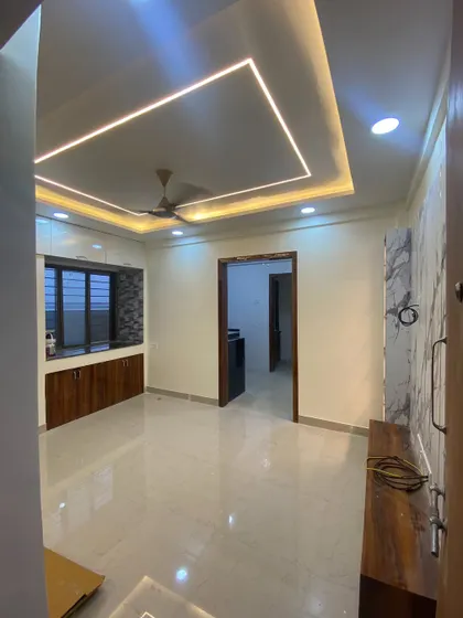 A shot of the living room showing the completed false ceiling with recessed and strip lighting, ready for the furniture to be moved in.