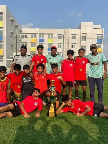 The U15 Gold Cup champions from the GIG International School tournament, posing with their coaches and trophy.
