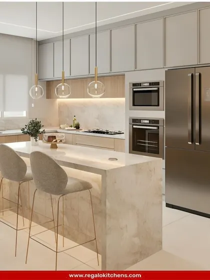This bright and welcoming island kitchen combines light wood cabinetry with a clean white marble island. The integrated appliances and breakfast bar make it a perfect hub for family activity, blending style with everyday practicality.