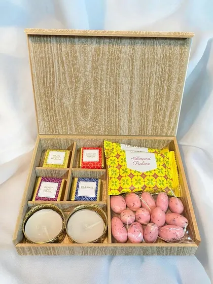 A beautiful wooden box curated with a mix of traditional and modern treats for Diwali. It includes assorted chocolates, almond pralines, strawberry almonds, and two decorative tea light holders.