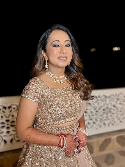 A happy and confident bride, ready for her sangeet. The makeup is designed to be magical and long-lasting, ensuring she looks her best all night.