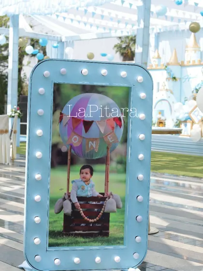 A close-up of a personalized, illuminated photo frame displaying a picture of one of the birthday twins. These custom details make the celebration deeply personal.