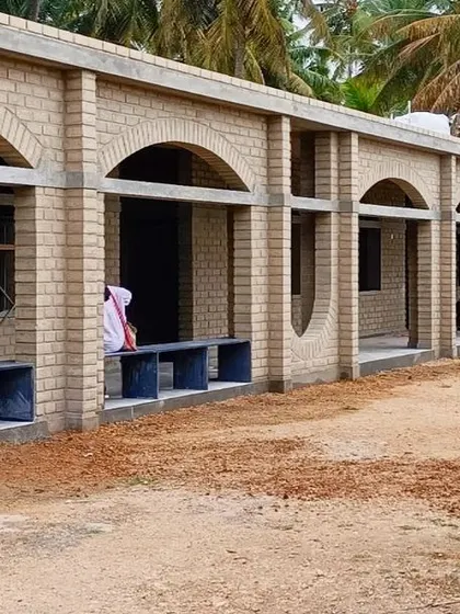 The classroom block at Sai Kirupa during construction, with its repeating arches and built-in corridor seating. The design creates a rhythmic and orderly facade that is also highly functional.