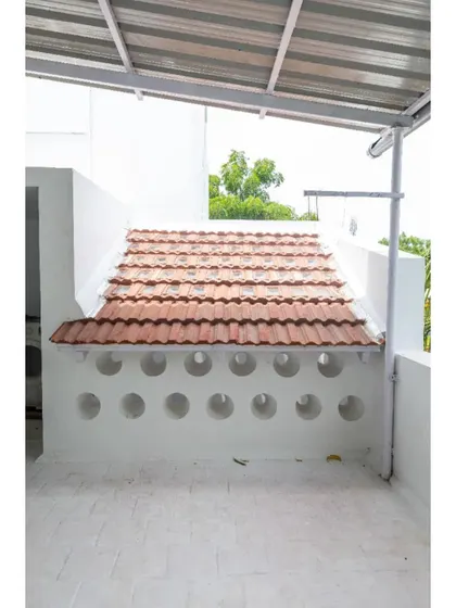 The rooftop terrace features a wall with circular openings, another innovative technique used in this project to manage light and airflow without conventional windows.