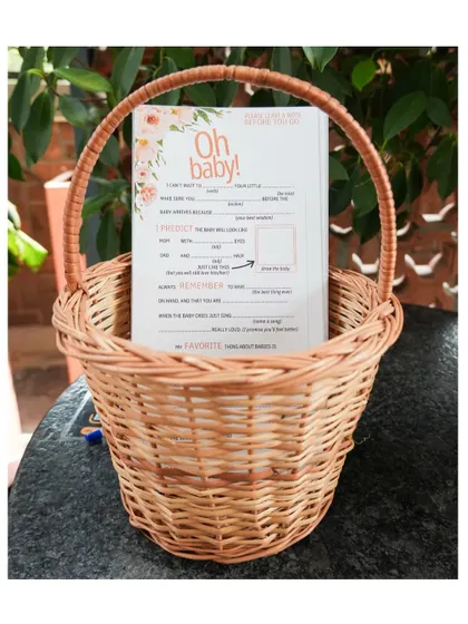 Thoughtful details include fun, interactive games. Here, "Oh Baby!" prediction and advice cards are ready for guests in a rustic wicker basket.