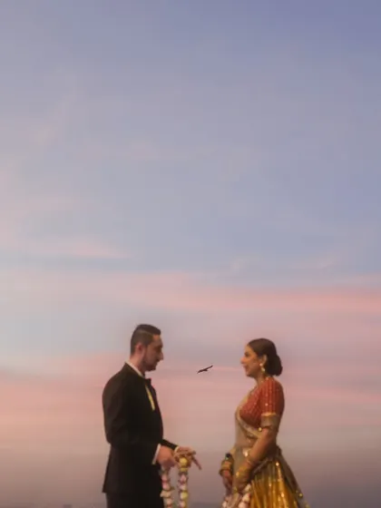 A minimalist and poetic shot of the couple during their sunset ceremony. A single bird flies between them, adding a touch of serendipitous magic to this beautiful moment.
