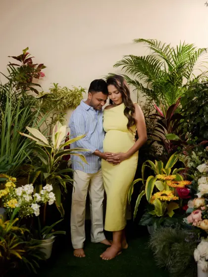 The father-to-be joins his partner in the indoor garden set, his hand gently on her bump. This shot captures their shared journey in a vibrant, naturalistic setting we created in the studio.