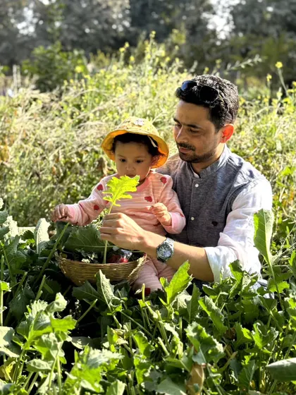 A father and child share a special moment while harvesting greens. We cherish being a place where families can connect with nature and each other.