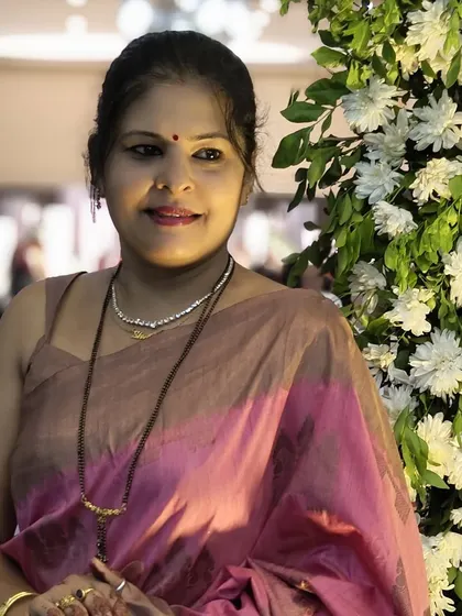 A portrait next to floral decor, where the pink of the saree complements the natural elements. Color coordination is a key part of my styling process.