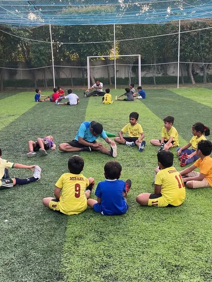 A coach leading a stretching session. Our coaches create an environment where young talents can thrive, both on and off the field.