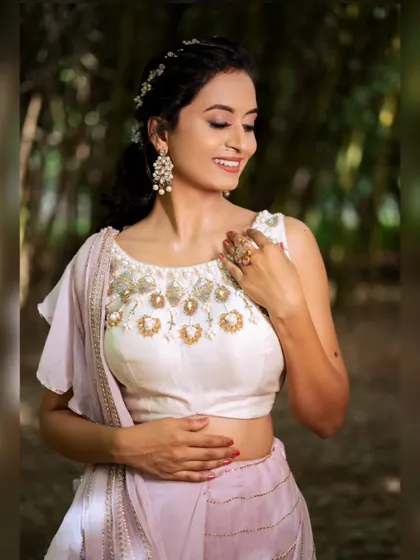 A close-up on the hand-embroidered blouse of the lavender saree, showcasing the detailed beadwork and craftsmanship.