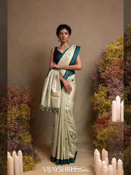 A model wearing a light green Banarasi kathan silk saree with silver zari floral motifs and a dark green border.