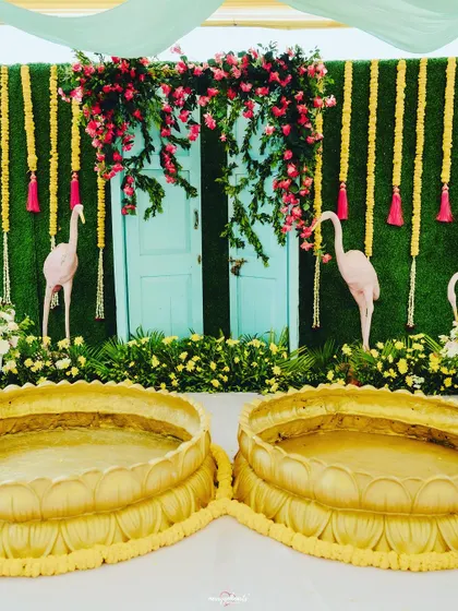 The lotus-shaped brass urlis for the couple to sit in during the Haldi ceremony, flanked by fun flamingo props.