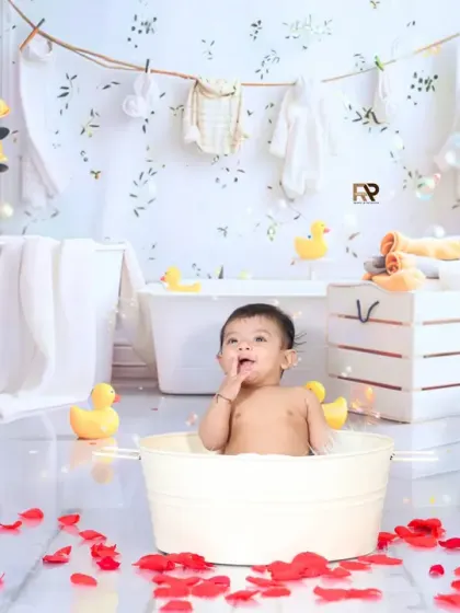 A beautiful splash session setup with a baby in a mini tub, surrounded by yellow roses, rubber ducks, and floating bubbles. The laundry line in the background adds a charming, rustic touch.