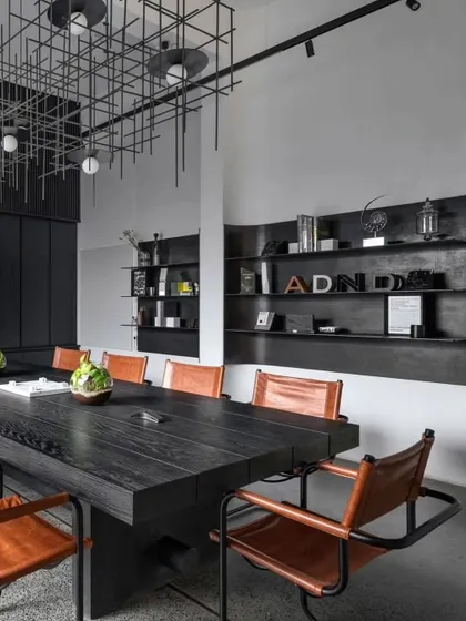 The main conference room features a large black table, leather chairs, and a custom grid-like light fixture, creating a powerful and sophisticated meeting space.